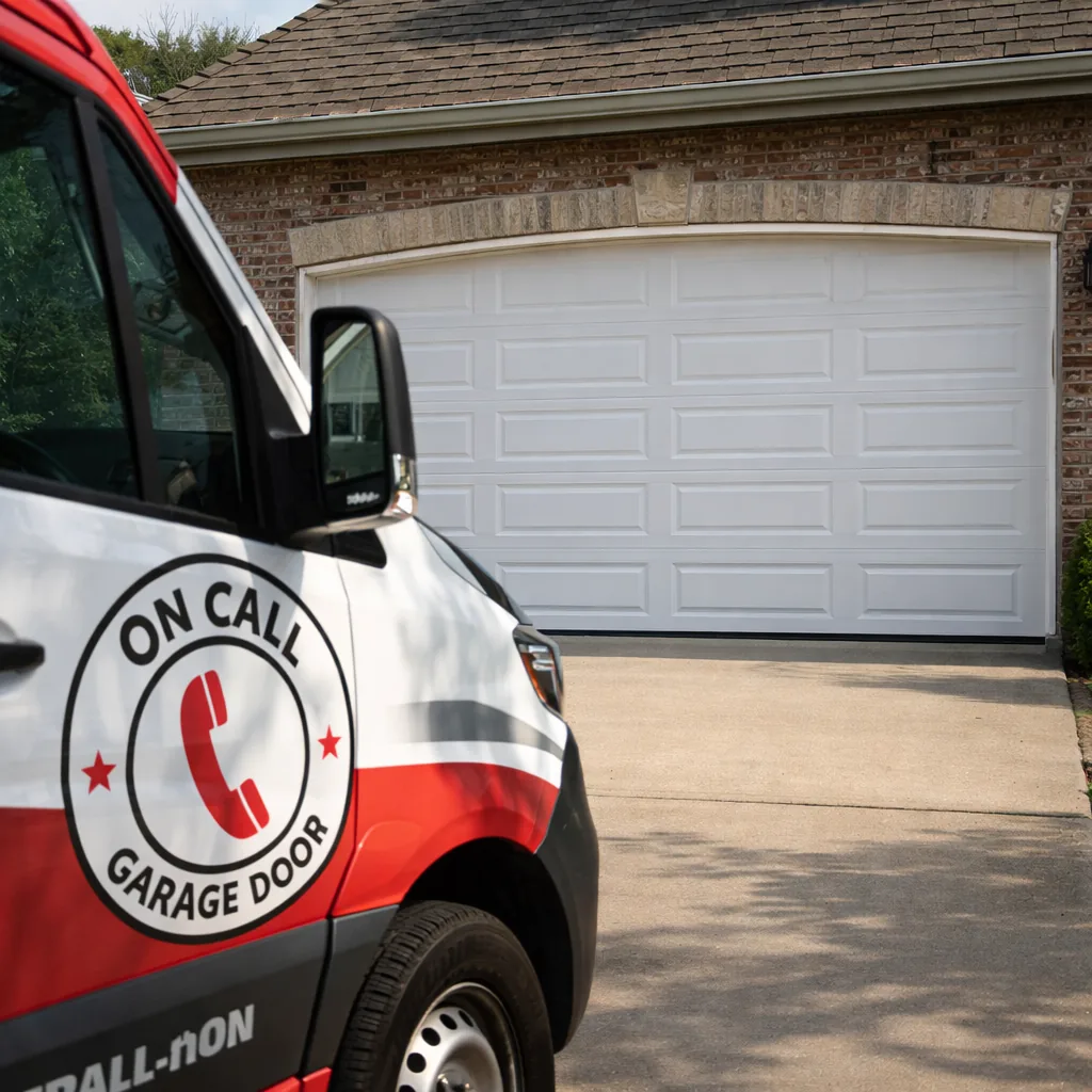 A newly installed insulated steel garage door on a Kansas City area home, closed and freshly finished, photographed from the driveway in daylight